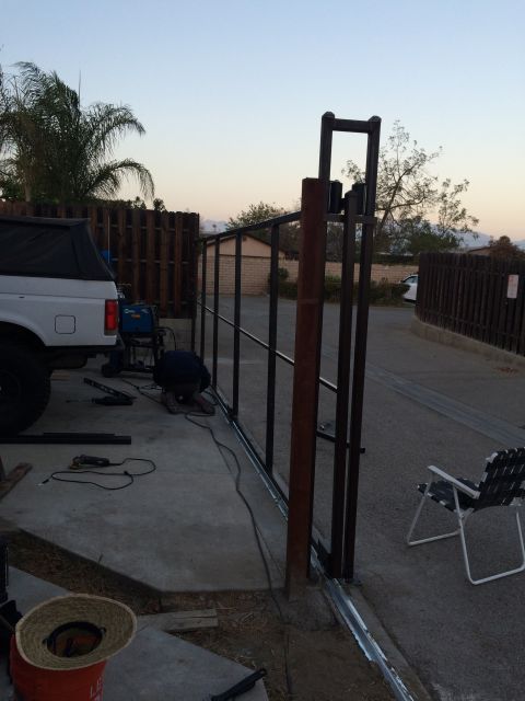 1968 Ford Mustang - A white SUV is parked on a concrete surface near a metal gate being installed.
