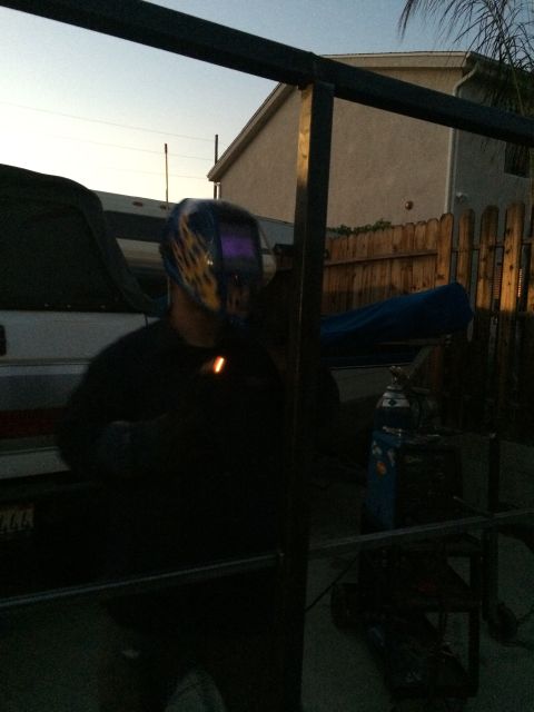 1968 Ford Mustang - A person in a welding mask is working outdoors, with a boat visible in the background.