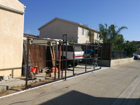 1968 Ford Mustang - A white pickup truck is partially visible behind a metal gate structure under a clear blue sky.