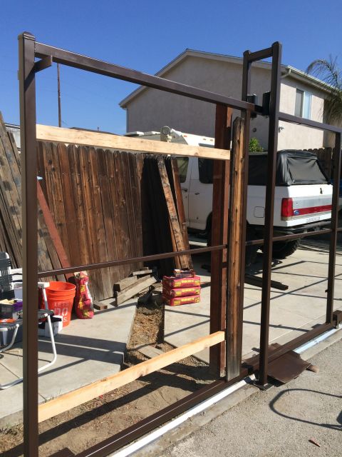 1968 Ford Mustang - White Ford pickup truck with a black camper shell is parked behind a partially constructed gate.