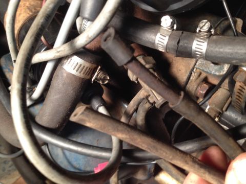 1973 Ford Bronco - A tangle of hoses and wires in a vehicle's engine compartment, showing signs of wear.