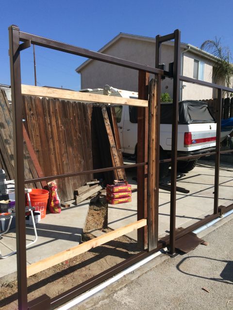 1968 Ford Mustang - A white pickup truck with a black soft top is parked behind a partially constructed gate.