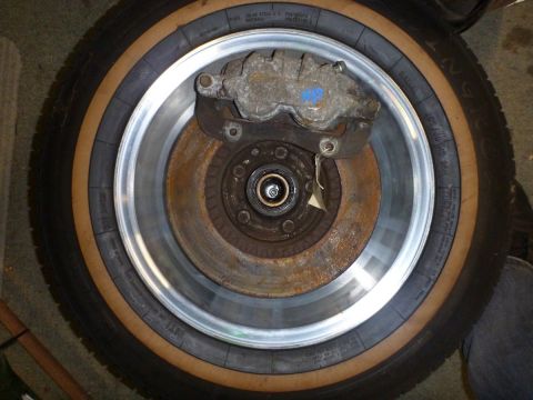 1964 Mercury Monterey - Close-up of a car's brake rotor and caliper, with a tire visible behind it.