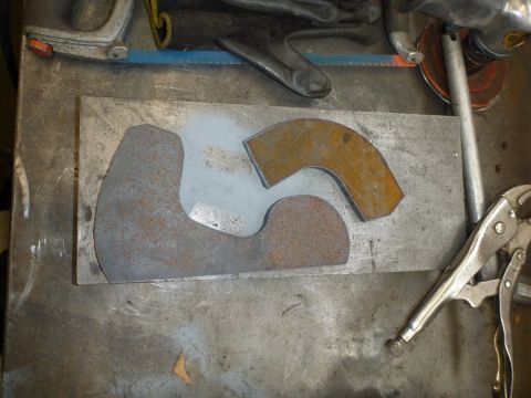 1964 Mercury Monterey - Metal parts cut from sheet metal on a workbench, held by a vise grip.