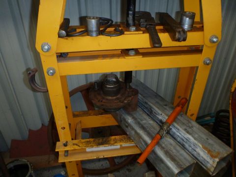 1964 Mercury Monterey - A hydraulic press is shown with a vehicle hub assembly and suspension parts, suggesting mechanical work.