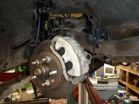 1964 Mercury Monterey - Close-up view of a vehicle's front suspension and brake system, with a disc brake and caliper prominently displayed.