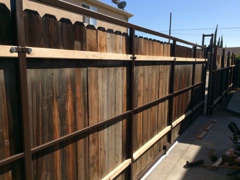 1968 Ford Mustang - A wooden fence with metal framing and supports is visible in a backyard setting.