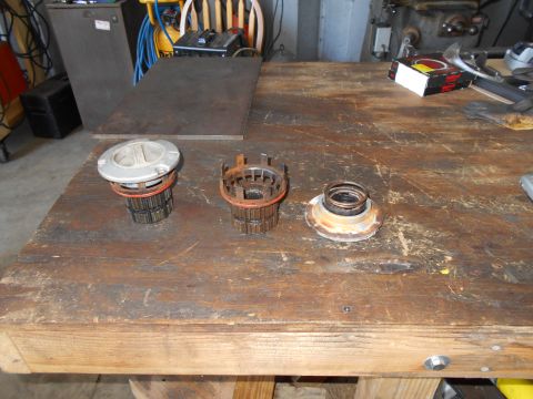 1992 Ford Bronco - Three automotive parts are displayed on a workbench, with tools and equipment in the background.