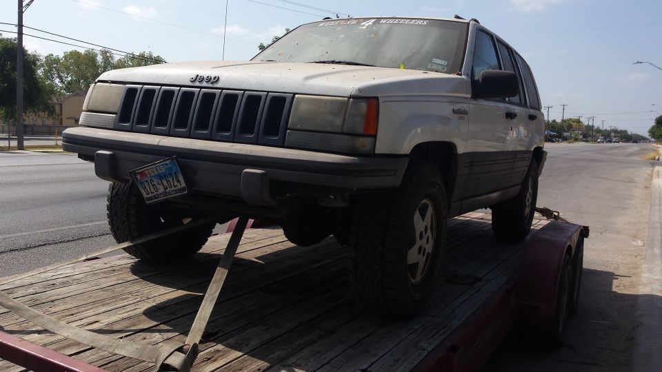 White 1994 Jeep Grand Cherokee on a trailer, front 3/4 view