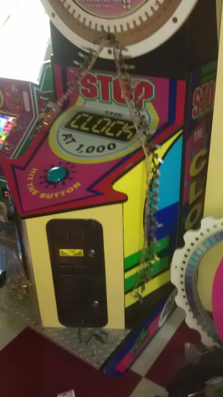 Arcade game cabinet with 'STOP THE CLOCK' text and a digital display showing 'AT 1,000'