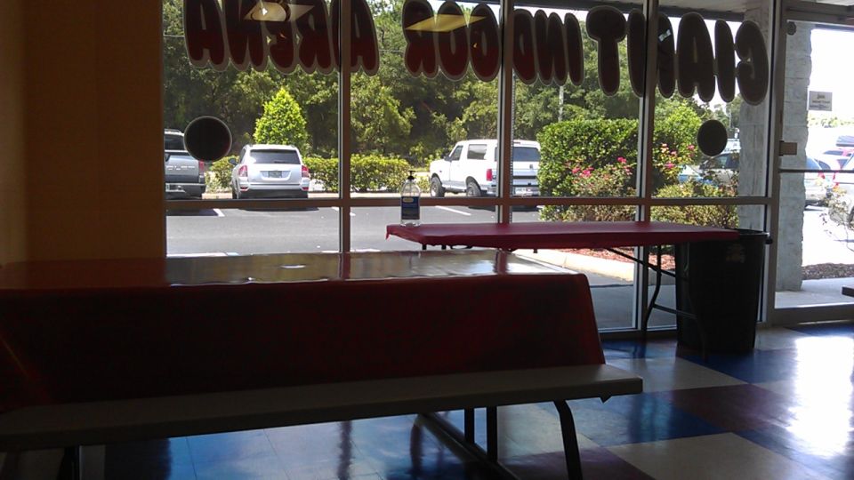 View of a parking lot through a window, showing several cars and trees