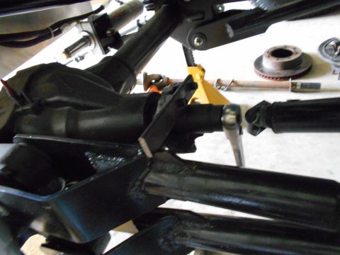 1992 Ford Bronco - Close-up of vehicle suspension components, including a differential and driveshaft, supported by a jack.