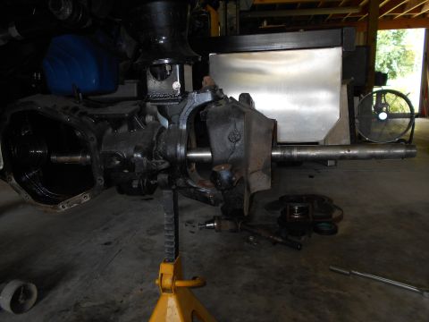 1992 Ford Bronco - Close-up of a vehicle's axle assembly, supported by a jack stand in a workshop setting.