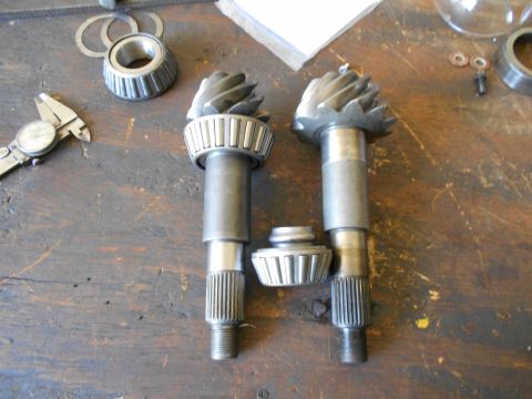 1992 Ford Bronco - Differential pinion gears and bearings laid out on a workbench with a caliper nearby.