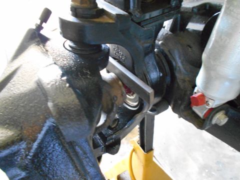 1992 Ford Bronco - Detail of vehicle suspension components, possibly during maintenance or repair, with a metal tool in place.