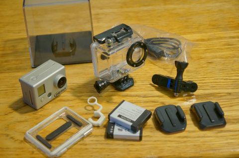 1993 Ford Taurus - A collection of GoPro camera gear, including the camera, protective case, batteries, and various mounting accessories.
