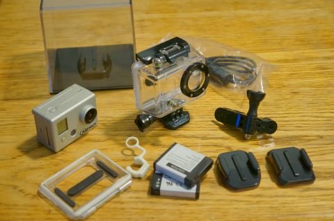 1993 Ford Taurus - A collection of GoPro cameras and their accessories are laid out on a wooden table.