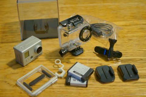 1993 Ford Taurus - A collection of GoPro cameras and accessories, including a silver HERO model, waterproof housing, batteries, and mounting hardware.