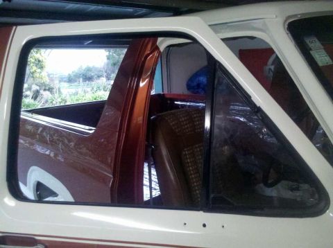 1982 Ford Bronco - Interior view of a white and brown Ford Bronco, revealing plaid upholstery and the cargo space.