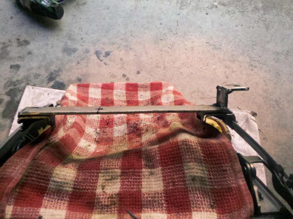 Close-up of a metal part covered by a red and white checkered blanket, with a black object in the upper left