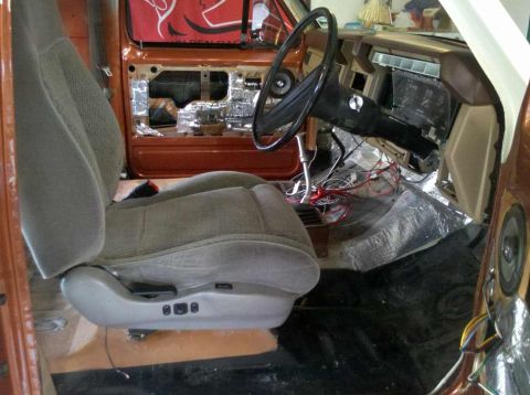 1982 Ford Bronco - Interior view of a vehicle undergoing modifications, showing exposed wiring and sound dampening material.