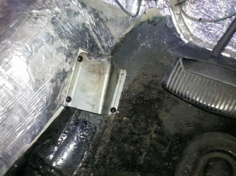 1982 Ford Bronco - Close-up view of the interior floor pan, showing a metal bracket and part of a pedal assembly. The Supermotors.net watermark is visible in…
