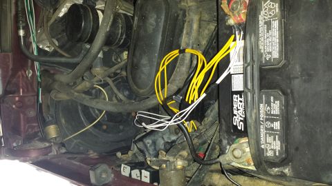 1996 Ford Bronco - Engine bay close-up showing a Super Start Extreme battery in its tray beside a bundle of new yellow and white wiring runs zip-tied over the…