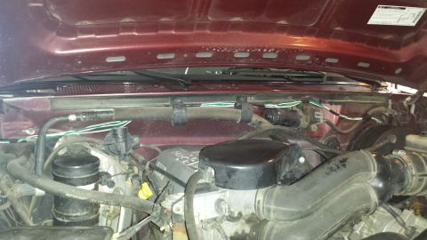 1996 Ford Bronco - Close-up view of a vehicle's engine bay, showing various mechanical parts and wiring.