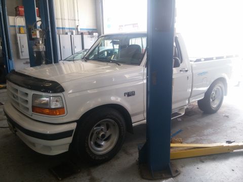 2000 Mercury Grand Marquis - A white pickup truck is parked in a garage, possibly for service.