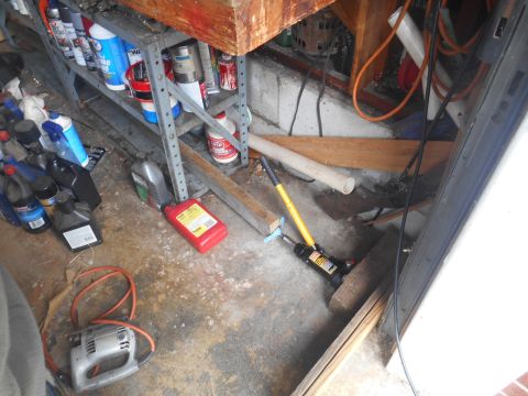 1994 Ford Bronco - A cluttered garage scene displays various automotive fluids, tools, and storage shelves.