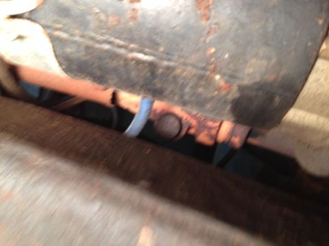 1973 Ford Bronco - Close-up view of an exhaust pipe and its mounting bracket, showing signs of rust and wear.