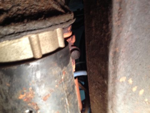 1973 Ford Bronco - Close-up view of heavily rusted metal parts, likely from a vehicle's chassis or drivetrain.