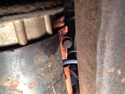 1973 Ford Bronco - This image shows a close-up view of the rusty undercarriage of a vehicle, focusing on mechanical components.