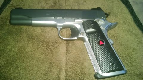 1979 Ford Bronco - A close-up view of a Colt Delta Elite pistol, a semi-automatic handgun with distinctive grip panels.