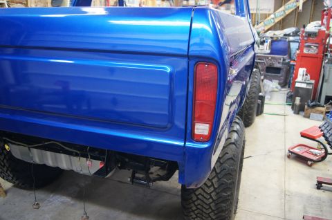 1979 Ford Bronco - A bright blue 1978 Ford Bronco is viewed from the rear, showing its large tires and taillight assembly.
