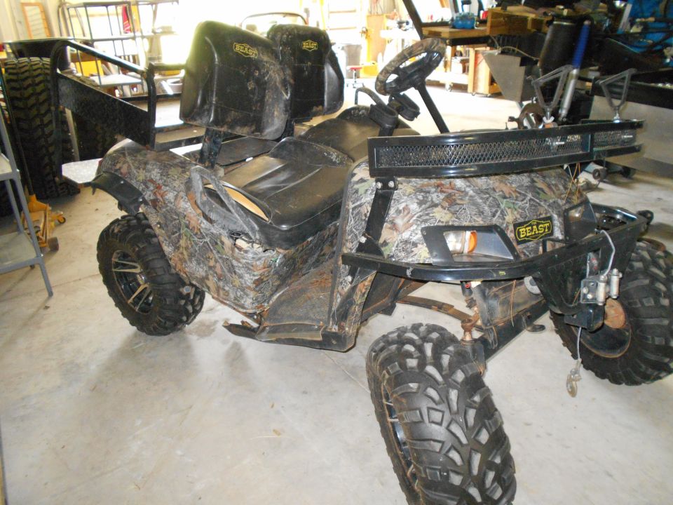 Camouflage ATV with black roll cage and knobby tires.