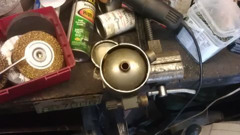 1994 Ford Bronco - A workbench scene with various tools and parts, including wire brushes, spray cans, a small metal canister, and a vise.
