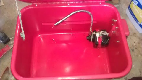1994 Ford Bronco - A red plastic tub with a pump and flexible hose is shown. A bottle of mineral spirits is visible in the background.