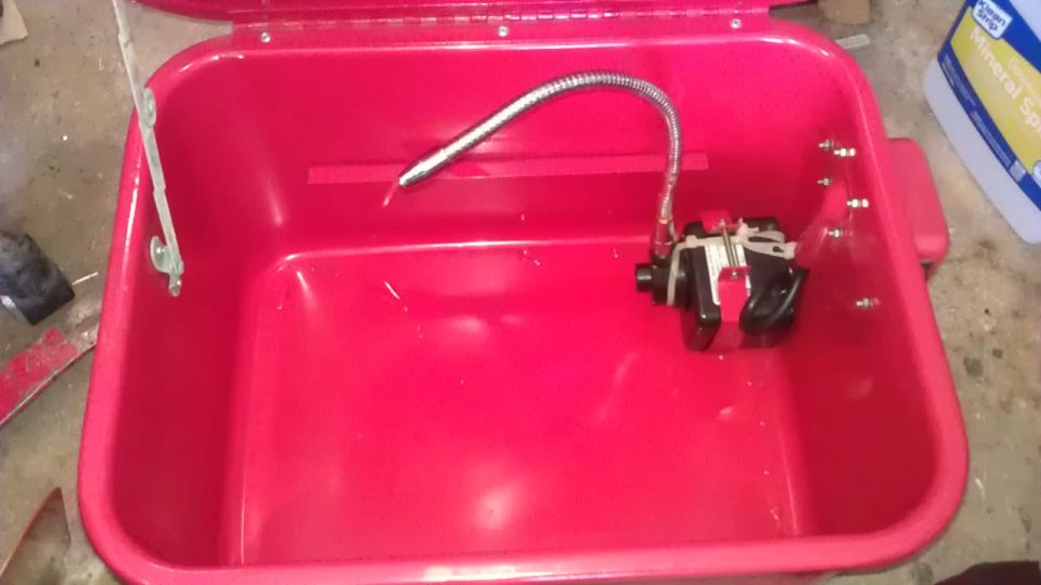 Red plastic tub with pump and mineral spirits bottle