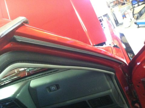1991 Jeep Comanche - The interior of a red 1991 Jeep Comanche shows the dashboard and door frame, with the hood open.