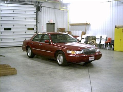 2000 Mercury Grand Marquis - Maroon 2000 Mercury Grand Marquis parked in a garage, facing a large overhead door.