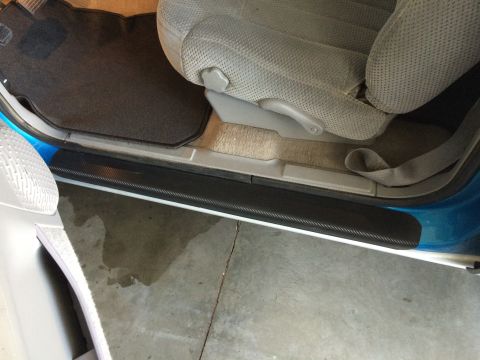 1995 Chevrolet Blazer - Close-up view of the interior door sill and seat of a vehicle, showing a carbon fiber trim piece.