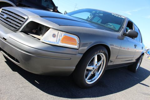 2003 Ford Crown Victoria - low dramatic angle on a gray Ford Crown Victoria's grille, headlight and chrome drag wheel wrapped in an M&H tire.