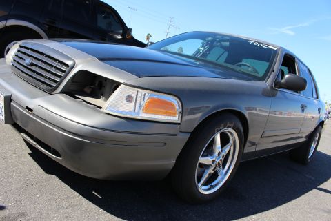 2003 Ford Crown Victoria - gray Ford Crown Victoria photographed front three-quarter, hood slightly open, sporting chrome five-spoke drag wheels.