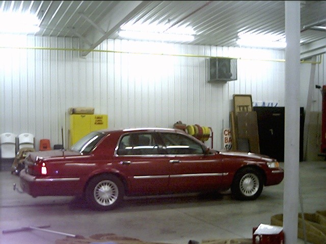 Red 2000 Mercury Grand Marquis parked inside a garage