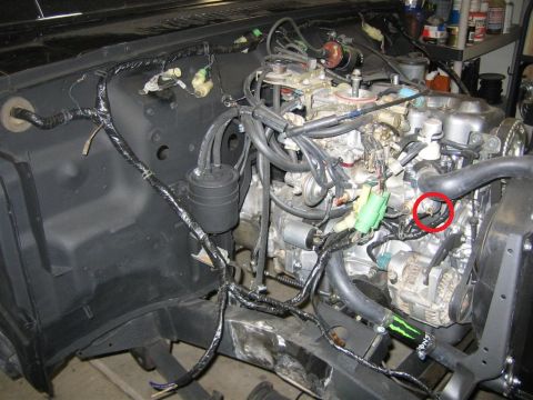 1987 Suzuki Samurai - Close-up view of an engine bay, showing various wires, hoses, and mechanical parts.