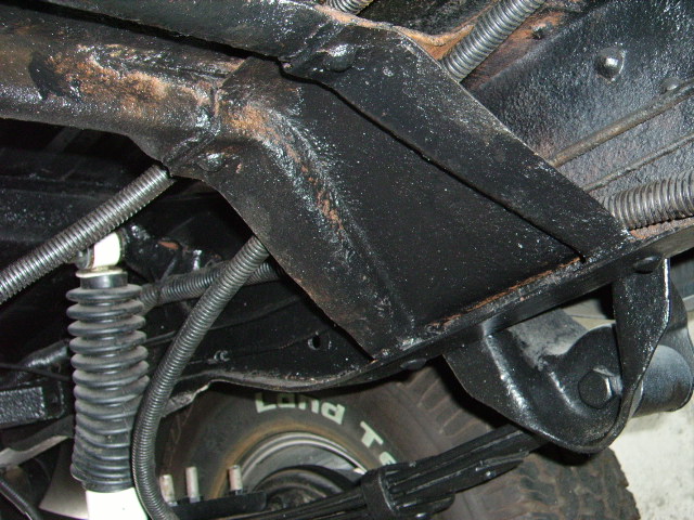 Underside of a vehicle showing frame, suspension, and tire with 'Land T' visible
