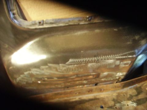 1978 Ford Bronco - Close-up of a vehicle's body panel reveals extensive welding and grinding, indicating repair work on a 1978 Ford Bronco.