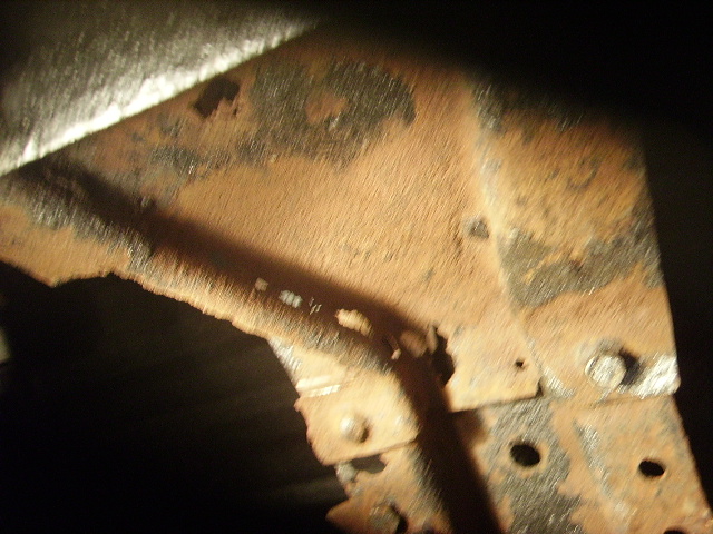 Close-up of heavily rusted metal frame components with bolts