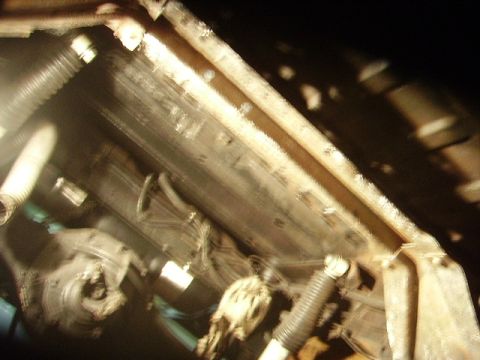 1978 Ford Bronco - Close-up of vehicle undercarriage components, including hoses and frame structure.